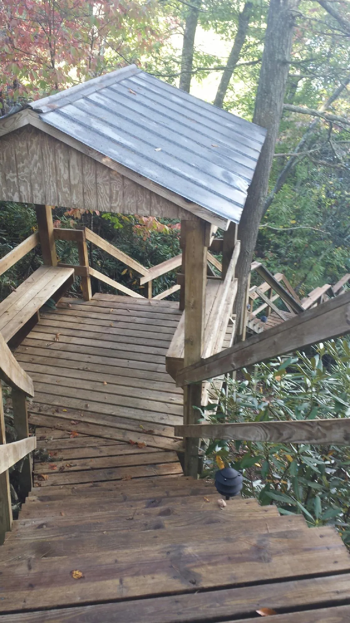 Metal roofed shelter over wooden steps on a wooded walkway — Skylight Repair & Installation work by our crew in Tullahoma
