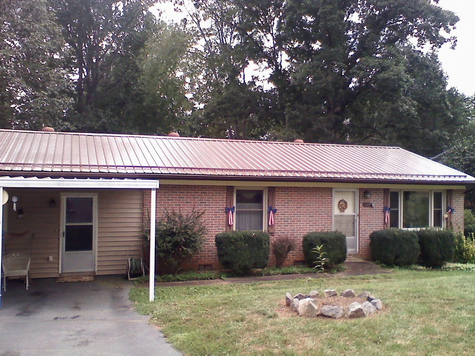 Bronze metal roof and carport on a brick ranch home — Roof Repair work by our crew in Tullahoma